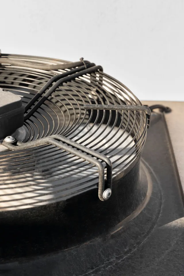 A close-up of a fan with a metal cage around it
